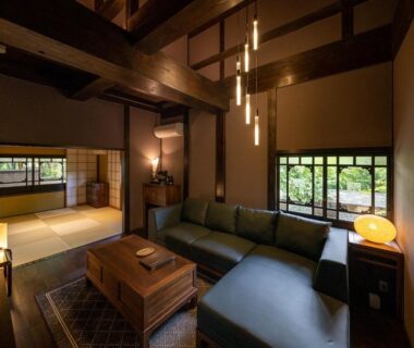 Interior with tatami, low wooden table, sofa, shoji screens and garden view at Nihon-no-Ashitaba, Ōita