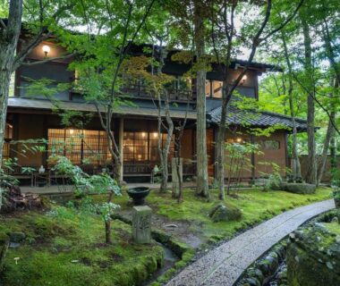 Wooden walkway through moss garden leading to a traditional ryokan building, Nihon-no-Ashitaba, Ōita, Kyūshū Japan