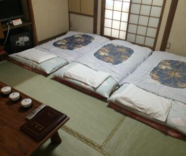 Three futon beds on tatami with shoji screens at Nihonkan in Kyoto, Kansai, Japan