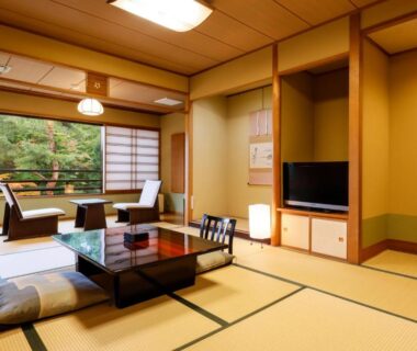 Spacious tatami room with low table, floor cushions, shoji screens and garden view at Nikko Hoshino Yado, Tochigi