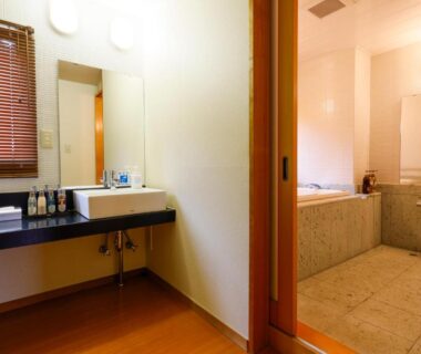 Bathroom with tiled bathtub and vanity separated by sliding door at Nikko Hoshino Yado, Tochigi