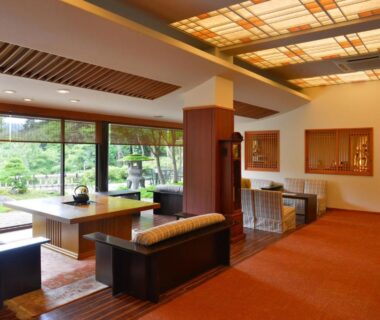 Lounge area with low wooden tables and large windows overlooking garden at Nikko Hoshino Yado Tochigi