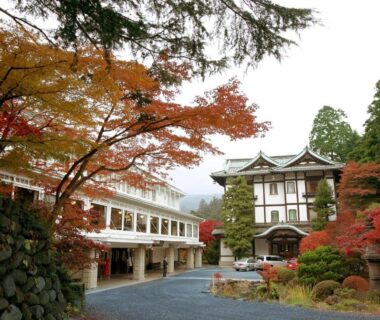 Autumn maple trees framing hotel entrance and stone courtyard at Nikko Kanaya Hotel, Tochigi, Kantō, Japan