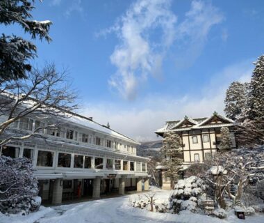 Snow-covered hotel buildings and trees at Nikko Kanaya Hotel in Tochigi, period architecture and winter grounds