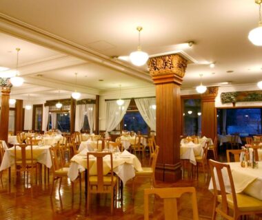 Spacious dining room with white tablecloths, chandeliers and wooden columns at Nikko Kanaya Hotel in Tochigi Kanto