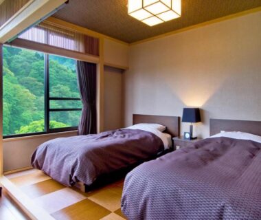 Tatami platform with twin beds and large window overlooking verdant hillside at Nikko Senhime Monogatari Tochigi