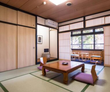 Tatami room with low table, zabuton cushions, shoji screens and window seating at Nikko Tokanso, Tochigi, Japan