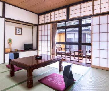 Traditional tatami room with low table, floor chairs and shoji screens at Nikko Tokanso in Tochigi