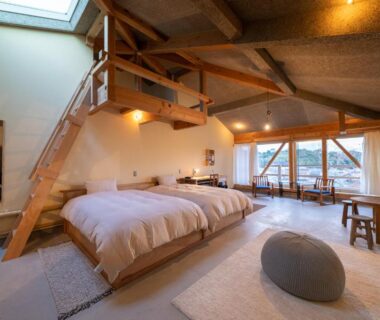 Spacious loft room with twin beds, exposed wooden beams, skylight and balcony at Nisainoyuyado Asahiya, Ōita