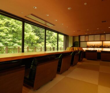 Tatami seating with low chairs and large windows overlooking greenery at Niseko Konbu Onsen Tsuruga Moku-no-sho Hokkaidō