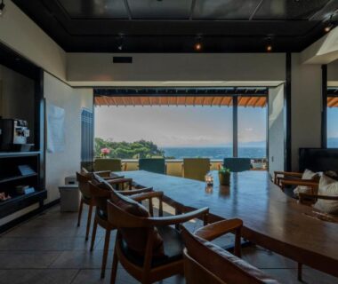 Open lounge with wooden seating and coastal view at Nishiizu Koyoi in Shizuoka