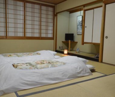 Traditional tatami room with futon, shoji screens and low lamp at Nissho Besso Kyoto
