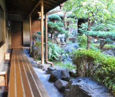 Covered wooden veranda with stone path and manicured garden at Nissho Besso Kyoto