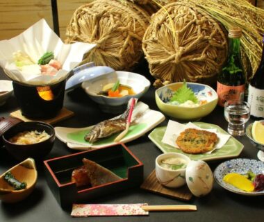 Assorted small Japanese dishes, sake bottle, lacquerware, chopsticks arranged on a low table at Nitaya in Gunma