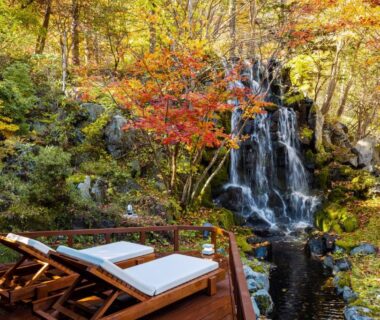 Deck loungers by a waterfall with autumn foliage at Noboribetsu Grand Hotel, Hokkaidō, Japan