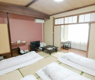 Tatami room with futons, low table and shoji screens at Nogami Honkan in Oita, Kyushu