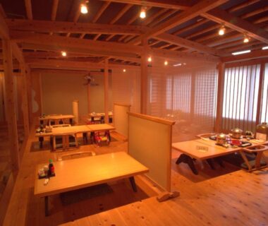 Traditional wooden dining area with low tables and shoji screens at Nogami Honkan in Ōita, Kyūshū, Japan