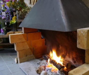 Stone hearth fireplace with glowing embers at Nonohanatei Komurasaki, Shizuoka