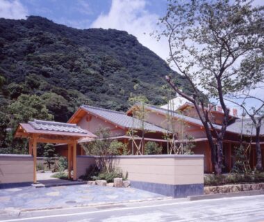Traditional wooden entrance gate and courtyard at Nonohanatei Komurasaki with mountain backdrop in Shizuoka, Chūbu, Japan
