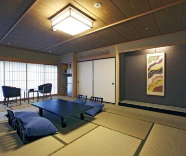 Tatami room with low table, cushions, shoji screens and alcove with hanging scroll at Notoya in Chūbu, Ishikawa, Japan