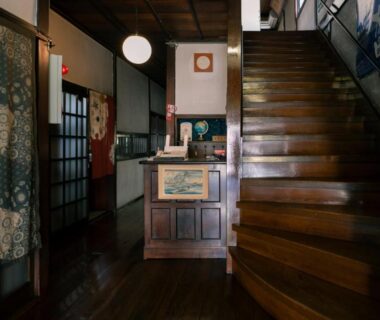 Interior with wooden staircase, reception counter, shoji screens and noren at Nunoya Ryokan in Nagano