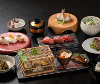 Assorted small plates including nigiri, bowls, lacquerware, and a wooden serving tray at ONCRI-Karatsu in Saga