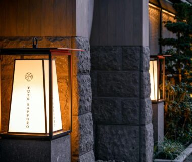 Paper lanterns and stone wall at Onsen Ryokan Yuen Sapporo entrance in Hokkaidō with warm lighting