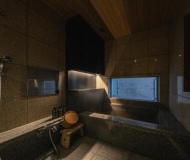 Tile-lined indoor bath with wooden bucket, hand shower and small window at OTARU RETREAT in Hokkaidō