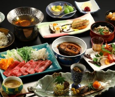 Assorted multi-course Japanese dishes with sashimi, simmered fish, raw beef slices and small side dishes at Ogiwarakan Nagano
