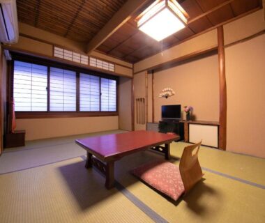 Tatami room with low table, floor chair, shoji screens and wooden ceiling at Ohanabo Kyoto