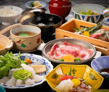 Assorted small Japanese dishes and thinly sliced meat arranged on a lacquered table at Ohanabo in Kyoto