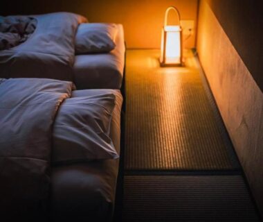 Low-lit tatami room with futon and lantern at Ohanabo in Kyoto