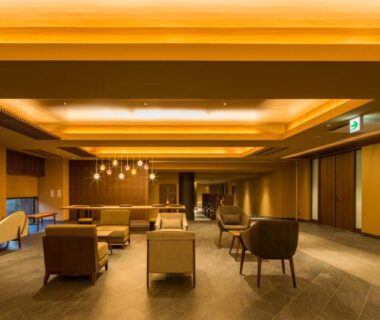 Warm-lit ryokan lounge with wooden furnishings and seating at Oike Hotel Yamanashi