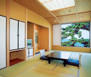 Traditional tatami room with low table, floor cushions, shoji screens and garden view at Oishiya in Mie