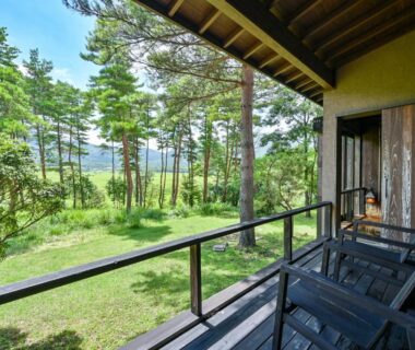Wooden veranda with chairs overlooking pine garden and hills at Oita Kuoritei, Ōita, Kyūshū, Japan