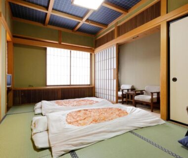 Tatami room with futons, shoji screens and low table at Okada Ryokan Warakutei in Gifu, Chūbu Japan