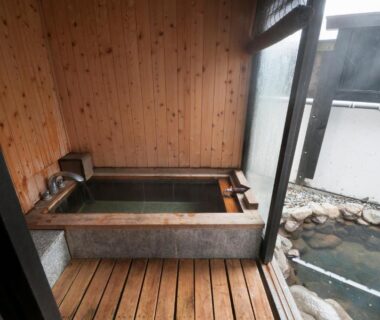 Indoor wooden soaking tub opening to outdoor stone bath at Okada Ryokan Warakutei, Gifu, Chūbu, Japan