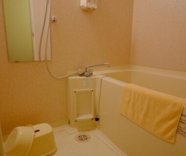 Compact unit bath with tub, handheld shower, stool and towel at Okuhida Garden Hotel Yakedake, Gifu
