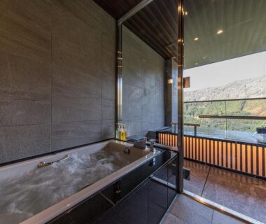 Indoor onsen bath at Okuhita Onsen Umehibiki overlooking hills in Ōita, Kyūshū