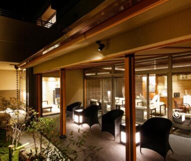 Warm lit courtyard lounge with armchairs and glass doors at Okuno Hosomichi in Hyōgo, Kansai