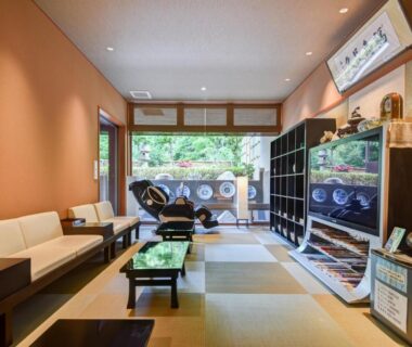 Ryokan lobby with tatami mats, low tables, sofa seating and garden view at Okuno Hosomichi Hyōgo