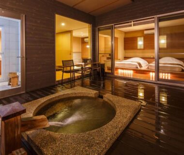 Wooden deck with stone bath outside guest rooms at Okuyado Buaiso in Oita