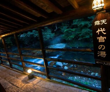 Lantern-lit wooden corridor beside river at Okyakuya, Kumamoto, Kyūshū