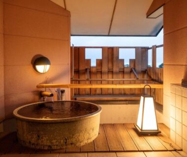 Round stone tub and wooden decking on outdoor bath terrace at Omoideno Jinde, Shizuoka