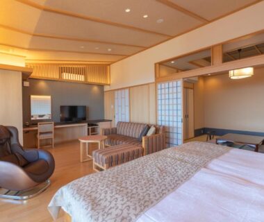 Spacious room with Western beds, tatami area, shoji screens and lounge seating at Omuro no Mori Gyokusui, Shizuoka