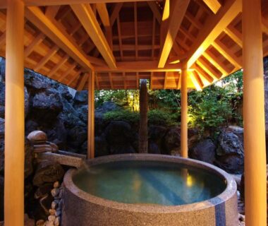 Circular stone onsen bath beneath wooden gazebo at Onishiya Suishoen, Hyōgo, Kansai