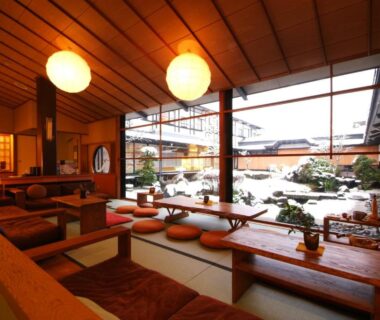 Low wooden seating with cushions facing a courtyard garden at Onishiya Suishoen Hyōgo