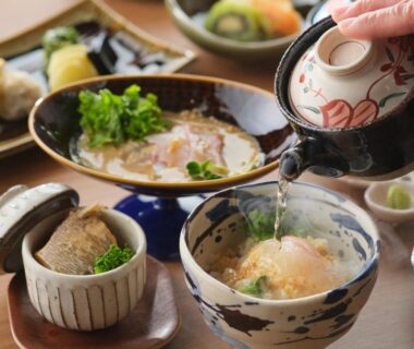 Bowls of Japanese broth being poured with small side dishes at Onomichi Hansei, Chūgoku Hiroshima