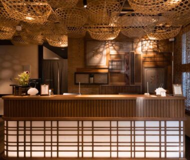 Traditional wooden reception with shoji-style panels and woven lanterns at Onsen Guest House Tsutaya in Kanagawa