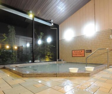Indoor tiled onsen bath with glass wall and handrail at Onsen Urashima, Hiroshima, Chūgoku, Japan